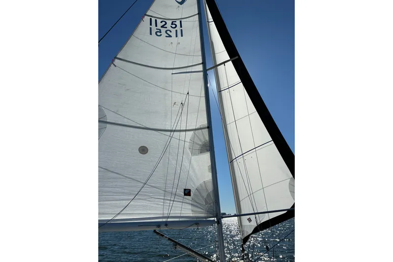Slide: The Image of Sails of a 1991 Tartan 28 Piper yacht against a clear blue sky. - 29