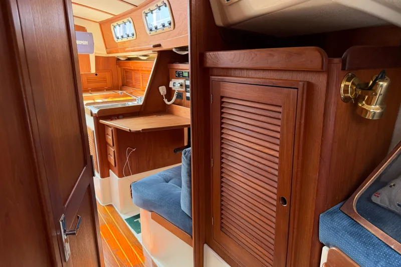 Slide: The Image of Interior of 1991 Tartan 28 Piper sailboat with wooden cabinetry and blue seating. - 20