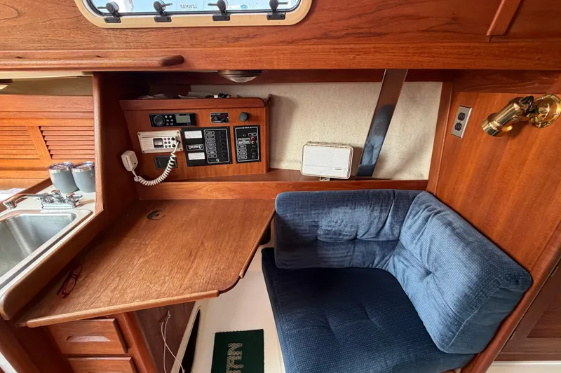 Slide: The Image of Interior of 1991 Tartan 28 Piper sailboat with navigation station and blue cushioned chair. - 14