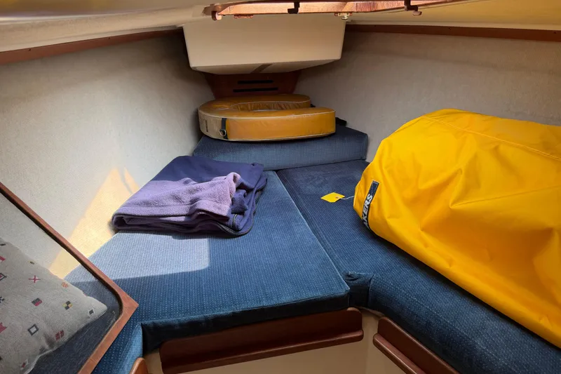Slide: The Image of Cozy cabin interior of 1991 Tartan 28 Piper sailboat with blue cushions and yellow bag. - 19