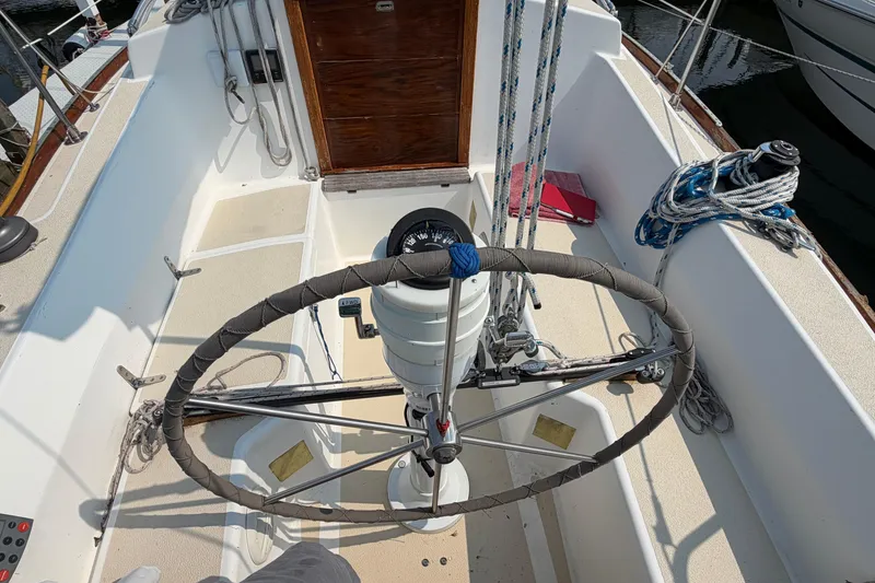 Slide: The Image of Cockpit of 1991 Tartan 28 Piper sailboat with steering wheel and nautical equipment. - 8