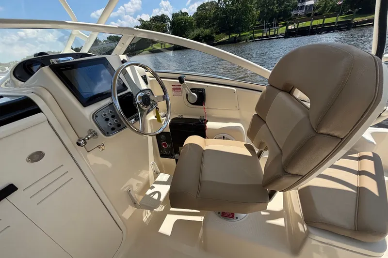 Slide: The Image of Interior of 2011 Scout 225 Abaco boat with steering wheel and beige seating. - 8