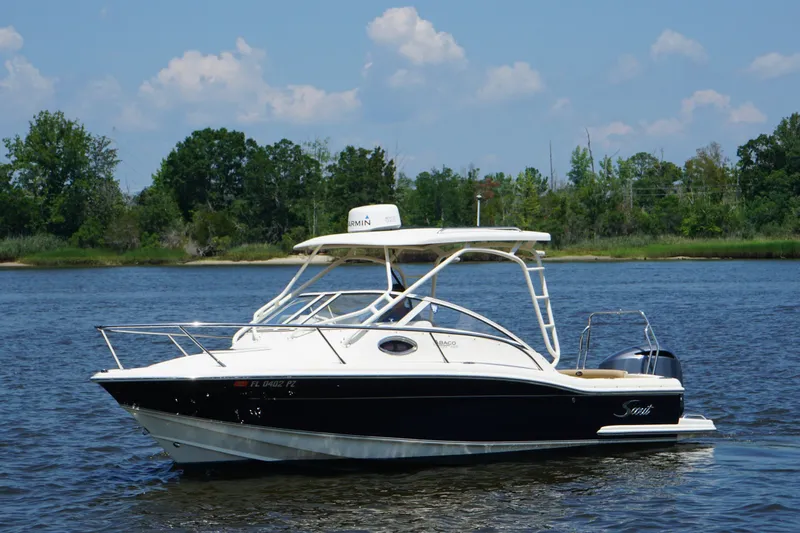 Slide: The Image of 2011 Scout 225 Abaco boat on a calm river with lush green shoreline. - 20