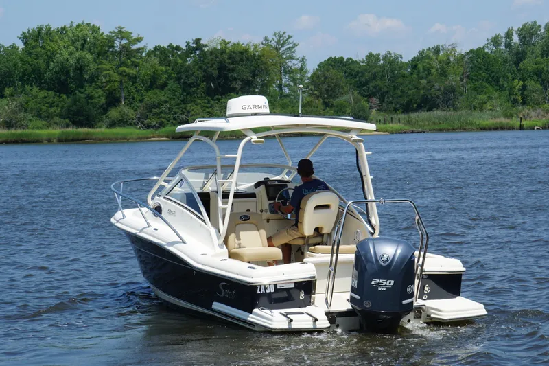 Slide: The Image of 2011 Scout 225 Abaco boat cruising on a river with lush green trees in the background. - 19