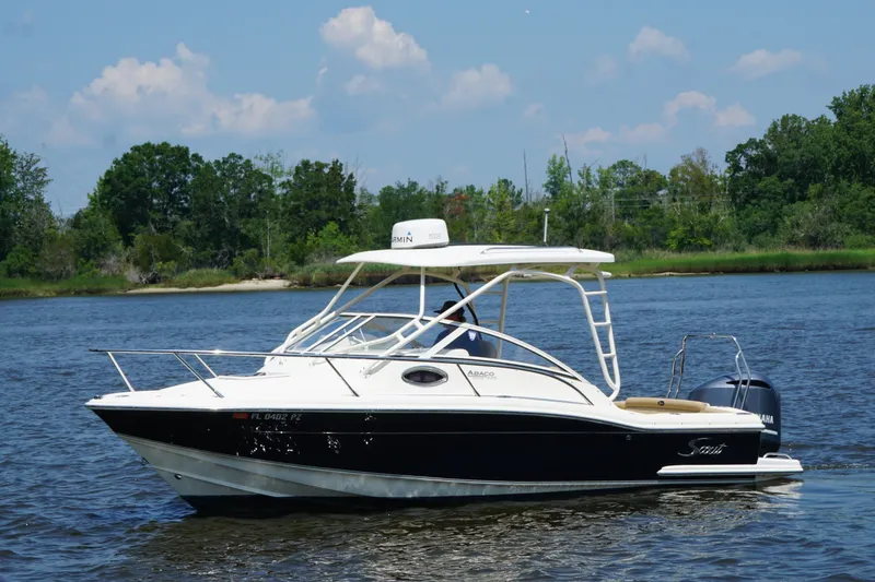 Slide: The Image of 2011 Scout 225 Abaco boat cruising on a serene river with lush greenery. - 17