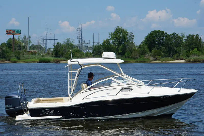Slide: The Image of 2011 Scout 225 Abaco boat cruising on a river with lush green background. - 16