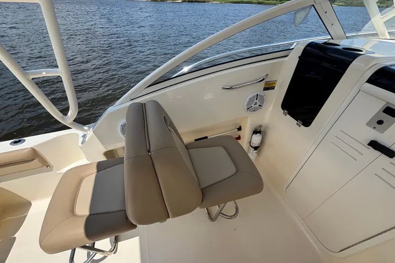 Slide: The Image of Interior view of 2011 Scout 225 Abaco boat with beige seating and water backdrop. - 12