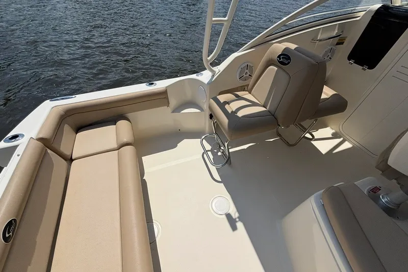 Slide: The Image of 2011 Scout 225 Abaco boat interior with beige seating and water view. - 13