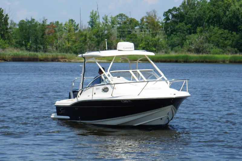 Slide: The Image of 2011 Scout 225 Abaco boat cruising on a calm river with lush greenery. - 18