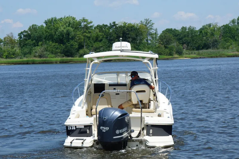 Slide: The Image of 2011 Scout 225 Abaco boat cruising on a scenic river with lush greenery. - 4