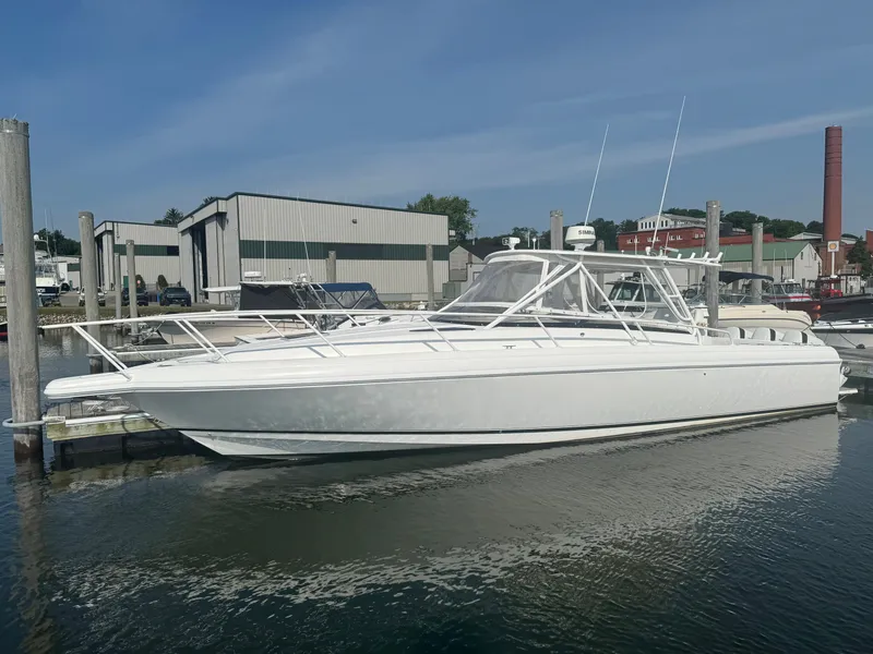 Slide: The Image of A white 2002 Intrepid 377 Walkaround boat docked in a harbor. - 1