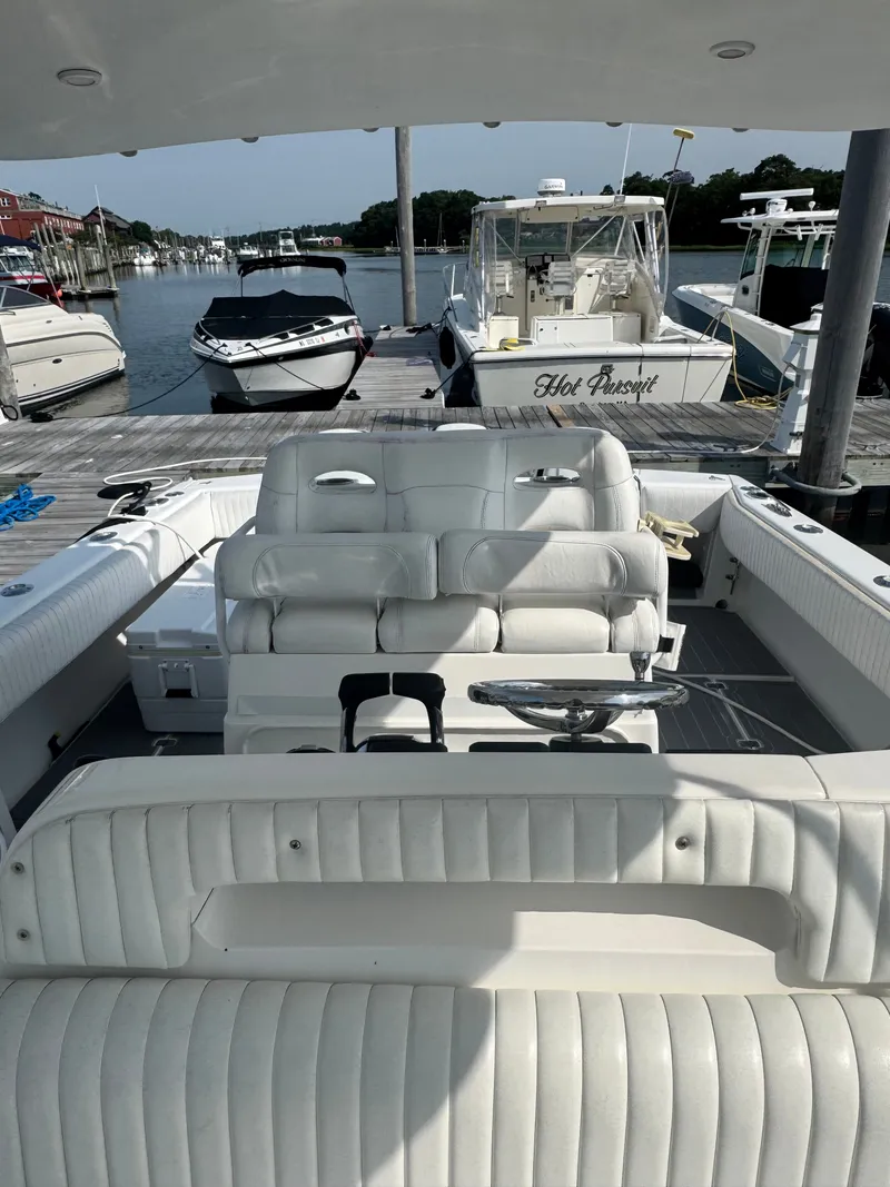 Slide: The Image of The image shows the cockpit of a 2002 Intrepid 377 Walkaround boat with white upholstery. - 9