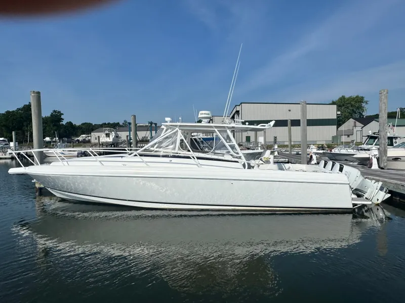 The Image of A white 2002 Intrepid 377 Walkaround boat docked at a marina. - 0