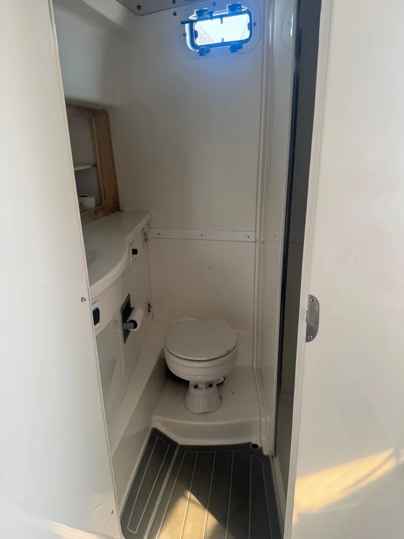 Slide: The Image of The image shows a clean, compact bathroom with a toilet and sink on a boat. - 11