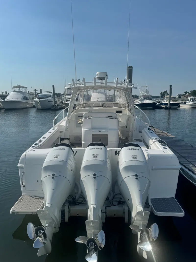 Slide: The Image of A 2002 Intrepid 377 Walkaround with three outboard engines docked at a marina. - 4