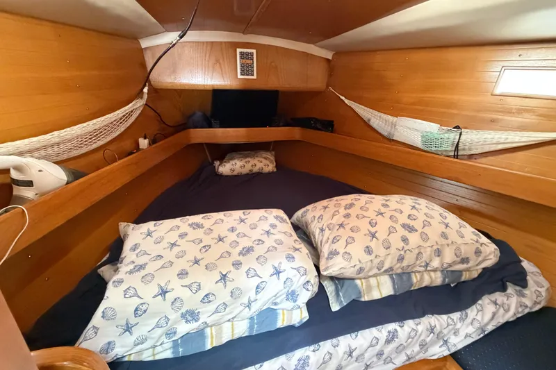 Slide: The Image of Cozy cabin interior of 1988 Beneteau Oceanis 390 sailboat with nautical-themed bedding. - 30