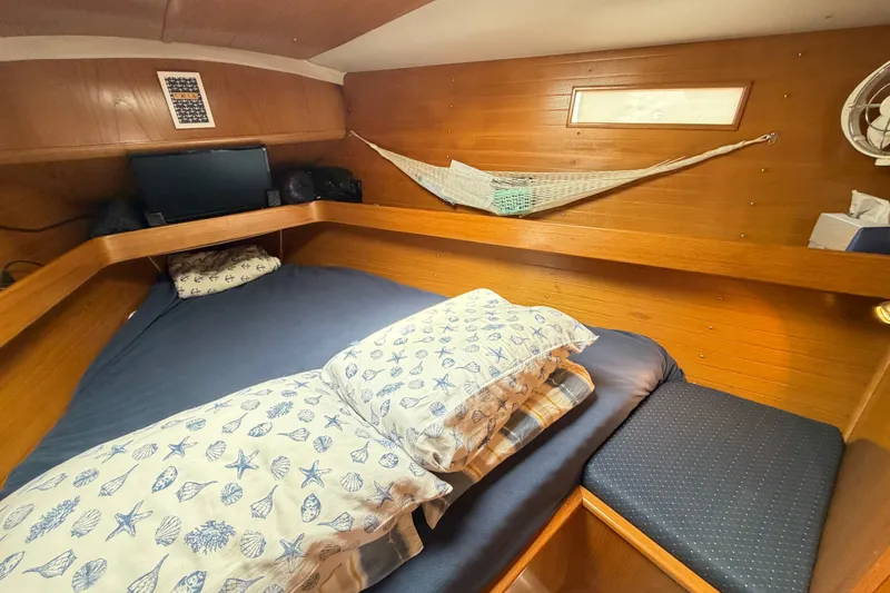 Slide: The Image of Cozy cabin interior of 1988 Beneteau Oceanis 390 sailboat with nautical-themed bedding. - 34