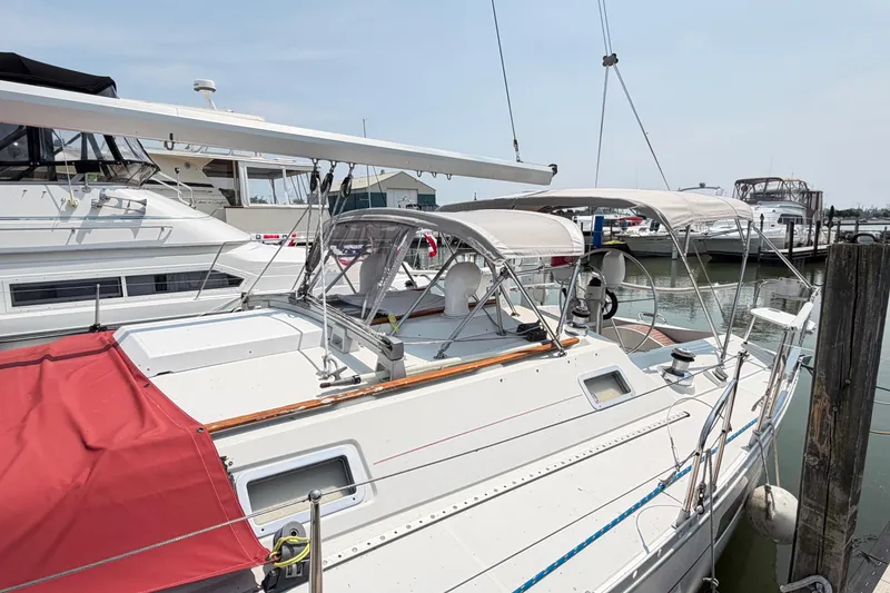 Slide: The Image of 1988 Beneteau Oceanis 390 sailboat docked at marina, featuring white hull and canopy. - 4
