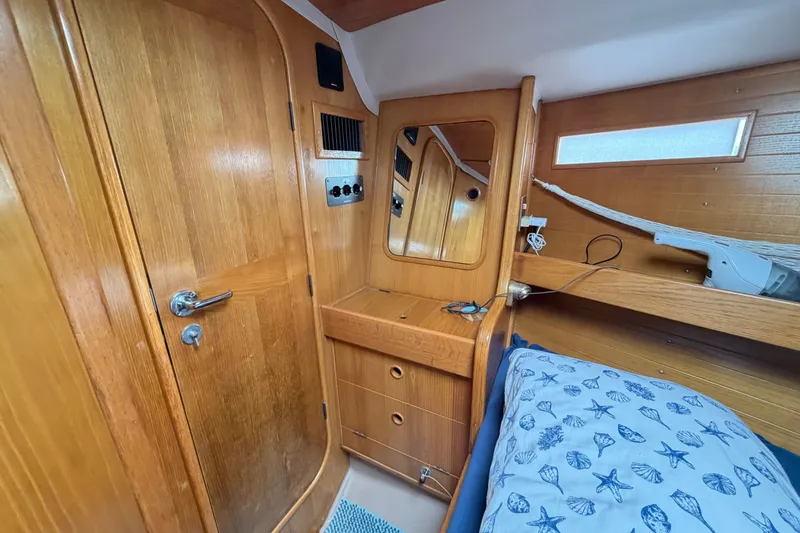 Slide: The Image of Cozy cabin interior of 1988 Beneteau Oceanis 390 sailboat with wooden finish and nautical bedding. - 44