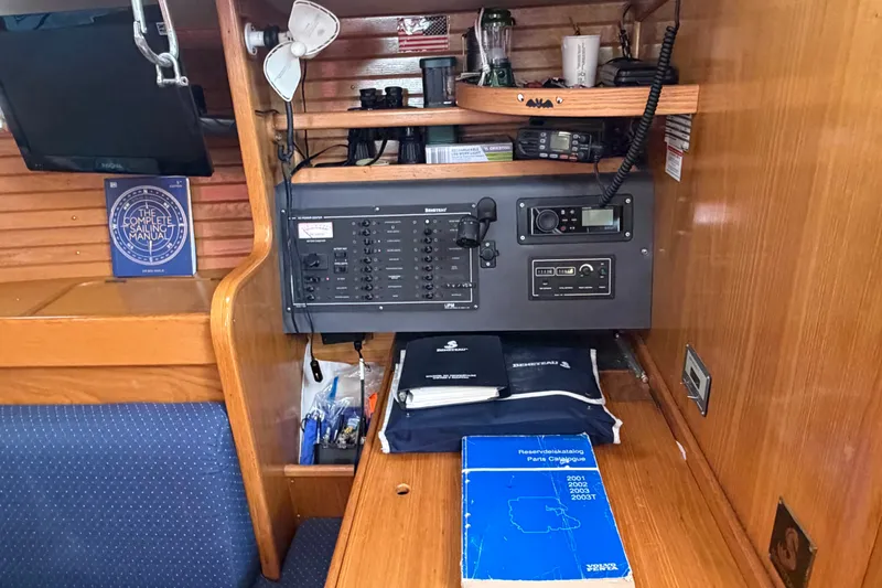 Slide: The Image of Navigation station on a 1988 Beneteau Oceanis 390 sailboat with manuals and equipment. - 27