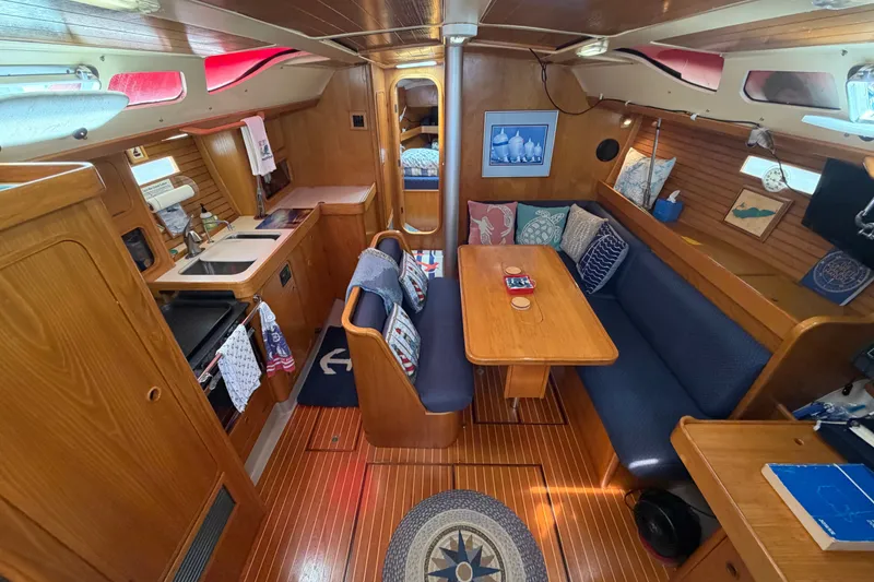 Slide: The Image of Interior of 1988 Beneteau Oceanis 390 sailboat with cozy seating and wooden finishes. - 16