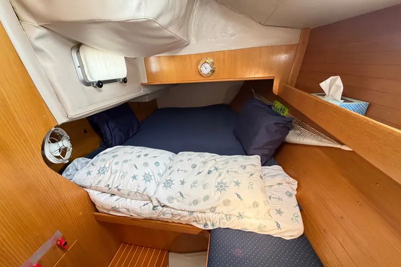 Slide: The Image of Cozy cabin interior of 1988 Beneteau Oceanis 390 sailboat with nautical-themed bedding. - 26