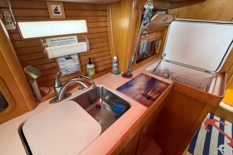Slide: The Image of Galley of 1988 Beneteau Oceanis 390 sailboat with sink, countertop, and storage. - 26