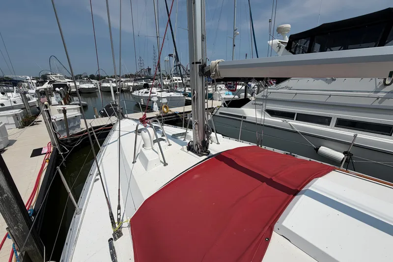 Slide: The Image of 1988 Beneteau Oceanis 390 sailboat docked at marina, featuring red deck cover. - 11