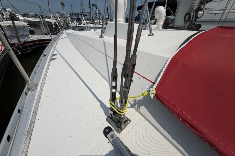 Slide: The Image of Deck view of 1988 Beneteau Oceanis 390 sailboat with red sail cover. - 12