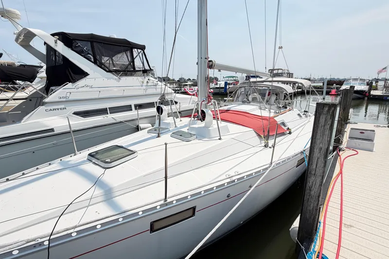 Slide: The Image of 1988 Beneteau Oceanis 390 sailboat docked at marina, alongside other boats. - 3