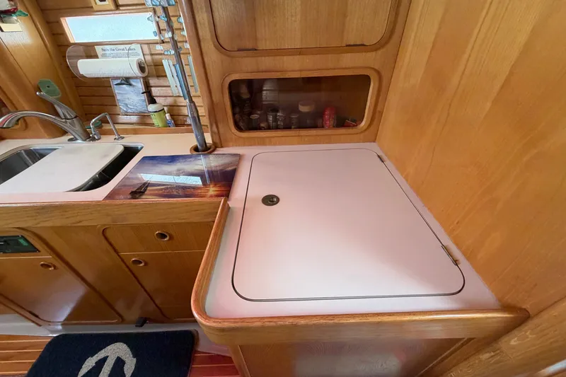 Slide: The Image of Interior of 1988 Beneteau Oceanis 390 yacht kitchen with wooden cabinetry and sink. - 23