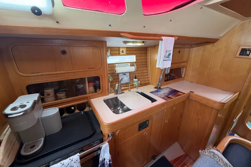 Slide: The Image of Interior of 1988 Beneteau Oceanis 390 yacht kitchen with wooden cabinetry and sink. - 20