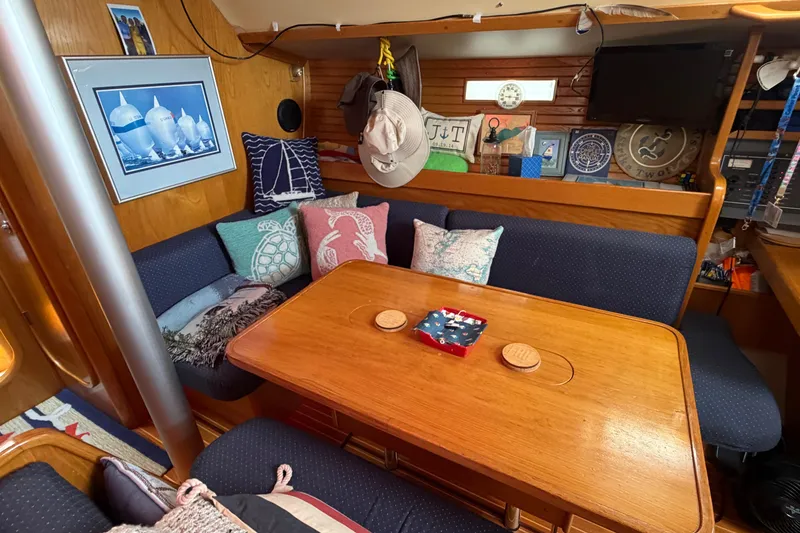 Slide: The Image of Cozy interior of 1988 Beneteau Oceanis 390 sailboat with wooden table and cushioned seating. - 23