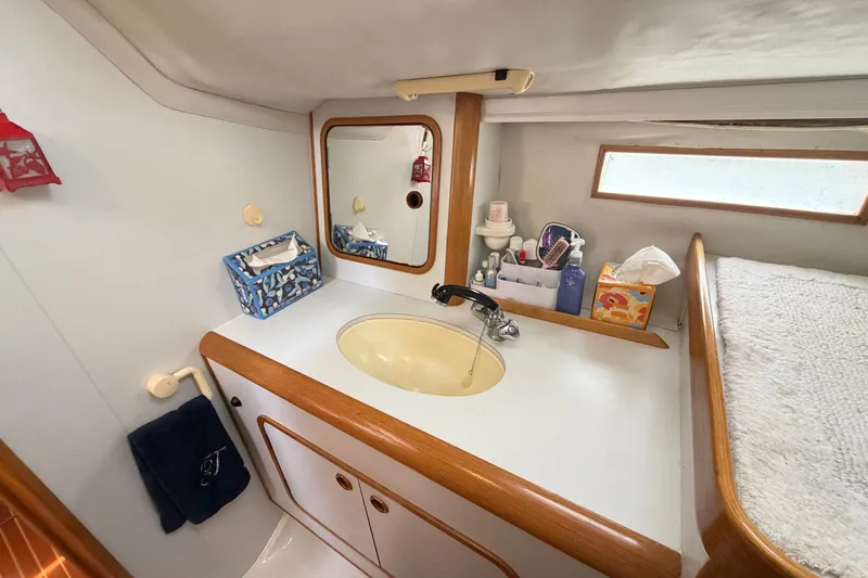 Slide: The Image of Bathroom interior of 1988 Beneteau Oceanis 390 yacht with sink, mirror, and toiletries. - 32