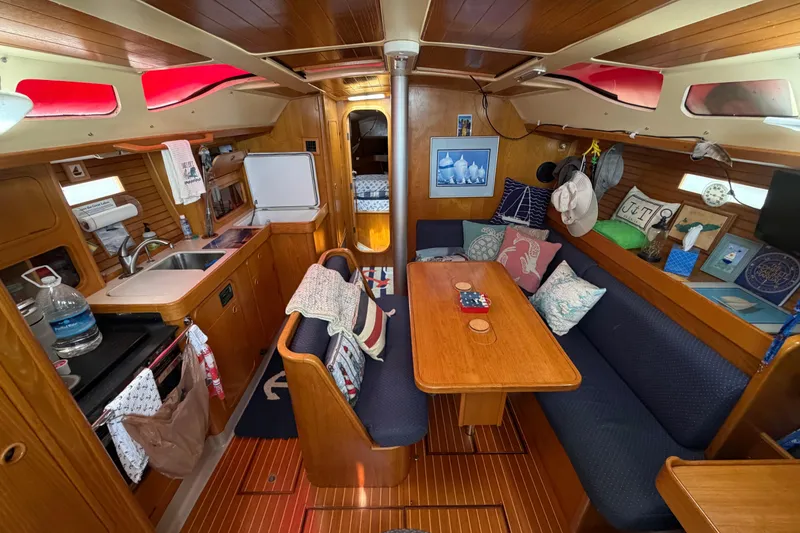 Slide: The Image of Interior of 1988 Beneteau Oceanis 390 sailboat with cozy seating and wooden finishes. - 17