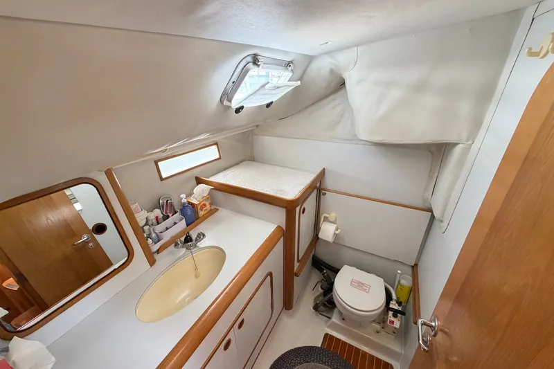 Slide: The Image of Interior of 1988 Beneteau Oceanis 390 yacht bathroom with sink, toilet, and storage. - 30