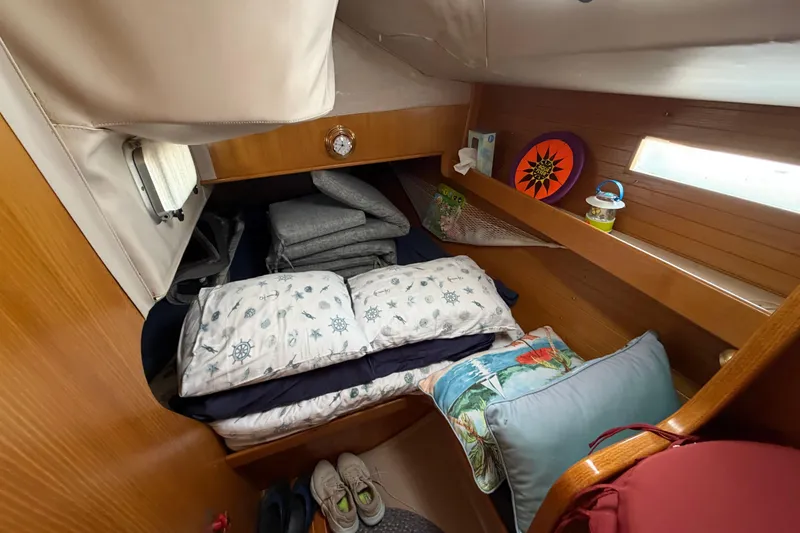 Slide: The Image of Cozy cabin interior of 1988 Beneteau Oceanis 390 sailboat with nautical-themed bedding. - 22