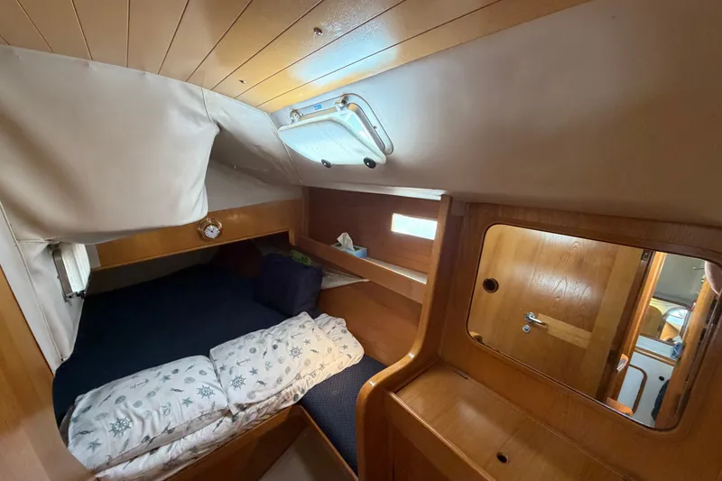 Slide: The Image of Cozy cabin interior of 1988 Beneteau Oceanis 390 sailboat with wooden finish and bedding. - 25