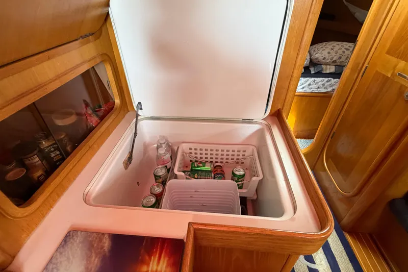 Slide: The Image of Interior of 1988 Beneteau Oceanis 390 yacht with open fridge and beverages. - 27