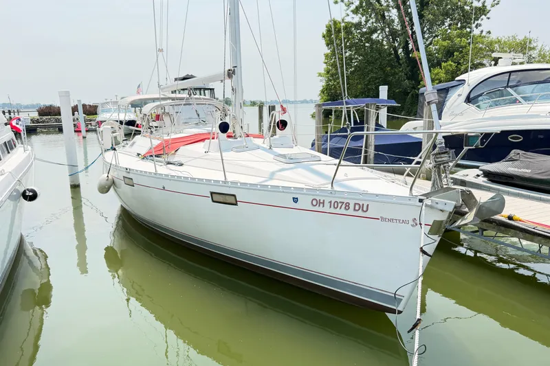 The Image of 1988 Beneteau Oceanis 390 sailboat docked in a marina, surrounded by other boats. - 1