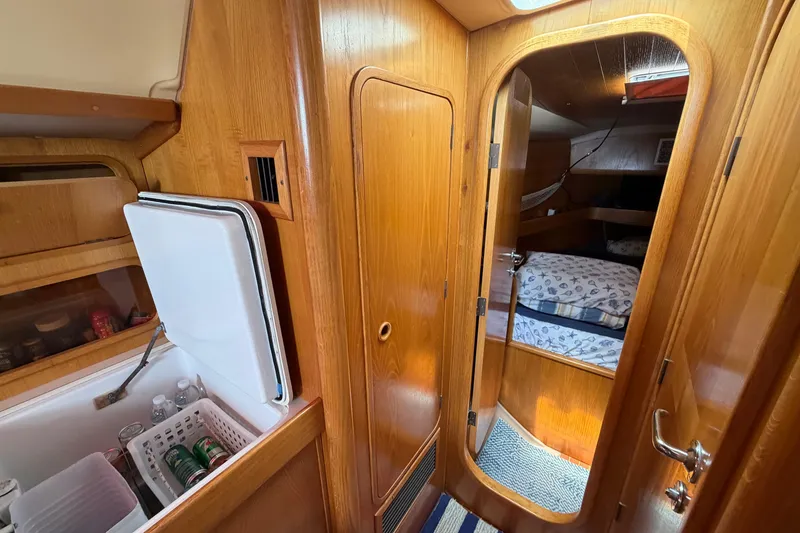 Slide: The Image of Interior of 1988 Beneteau Oceanis 390 sailboat with wooden cabinetry and cozy sleeping quarters. - 34