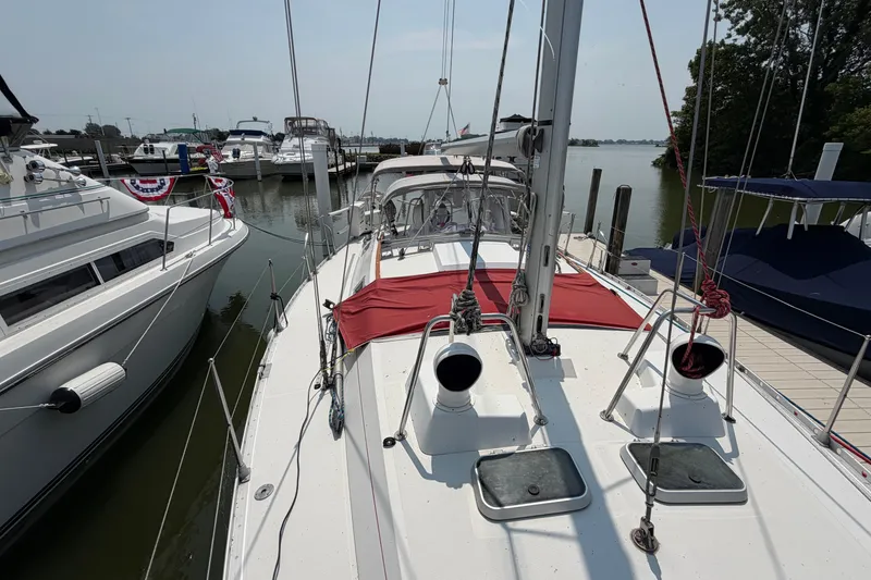 Slide: The Image of 1988 Beneteau Oceanis 390 sailboat docked at a marina, surrounded by other boats. - 15