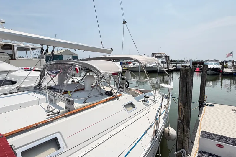 Slide: The Image of 1988 Beneteau Oceanis 390 sailboat docked at a marina, featuring a sleek design and canopy. - 5