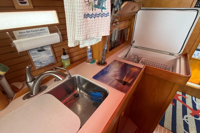 Slide: The Image of Galley of 1988 Beneteau Oceanis 390 sailboat with sink, countertop, and storage. - 25