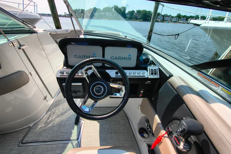 Slide: The Image of 2023 Crownline 290 SS boat cockpit with Garmin navigation system and steering wheel. - 10