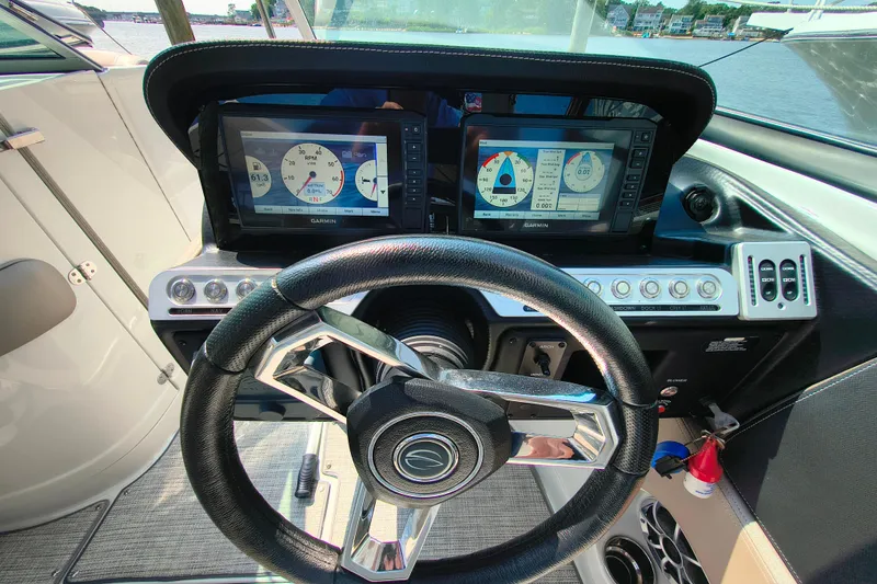 Slide: The Image of 2023 Crownline 290 SS boat dashboard with Garmin displays and steering wheel. - 11