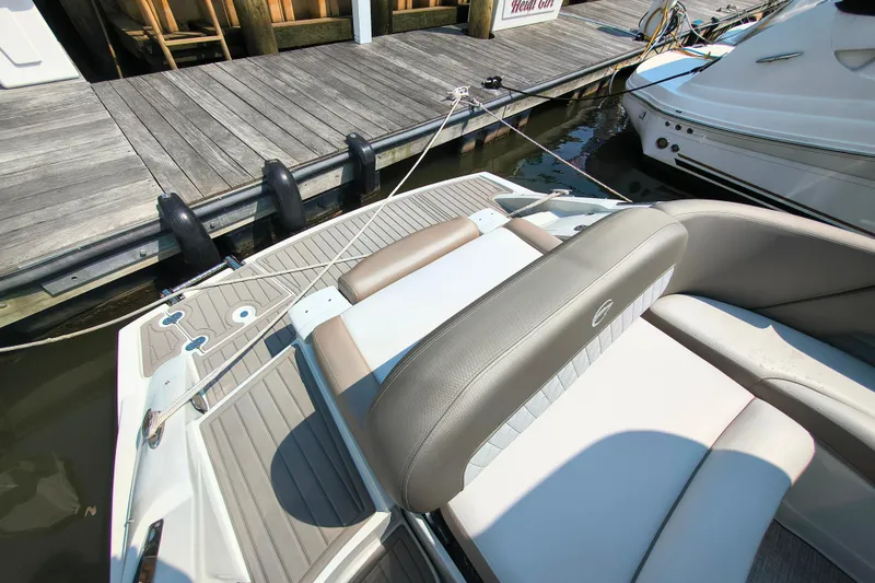 Slide: The Image of 2023 Crownline 290 SS boat docked, featuring sleek seating and modern design. - 8
