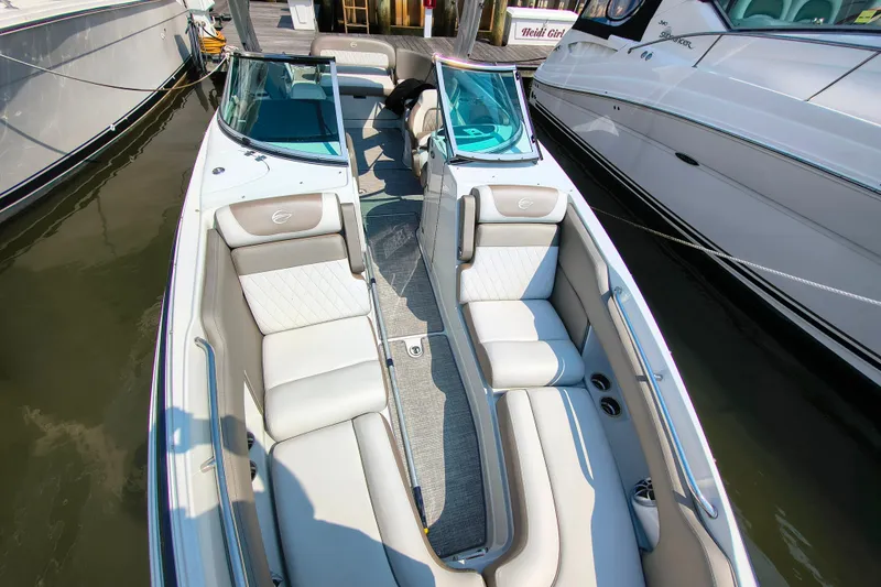 Slide: The Image of 2023 Crownline 290 SS boat interior with luxurious seating at a marina. - 13