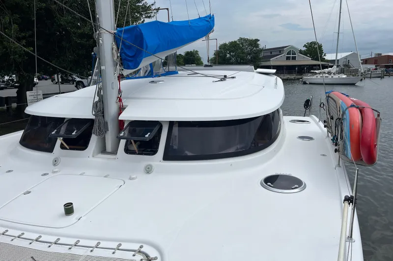 Slide: The Image of 2013 Fountaine Pajot Lipari 41 catamaran with blue sail cover, docked in a marina. - 4