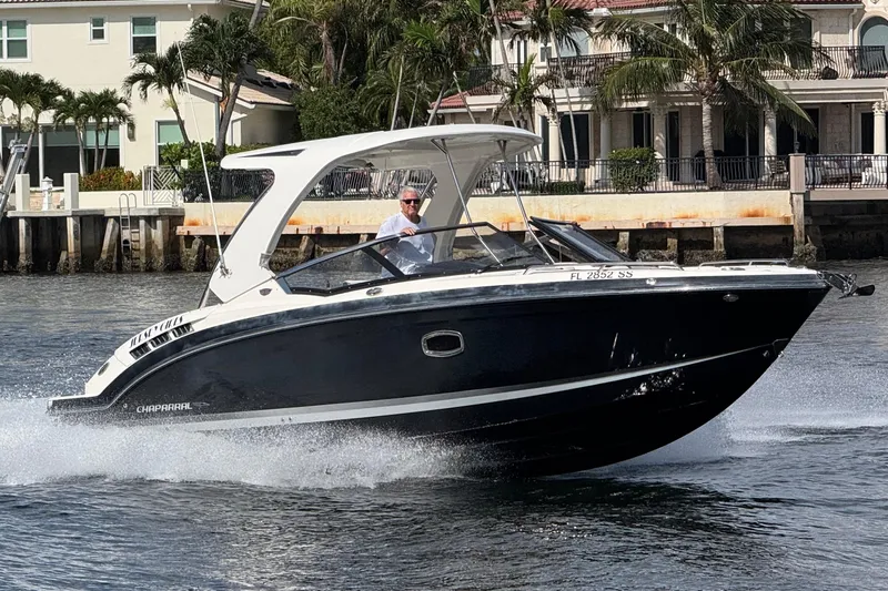 Slide: The Image of 2019 Chaparral 317 SSX boat cruising near waterfront homes. - 17
